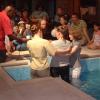 Natalie prepares herself to be immersed in the baptistery by Revds Fiona Robertsona and Beverly Watson
